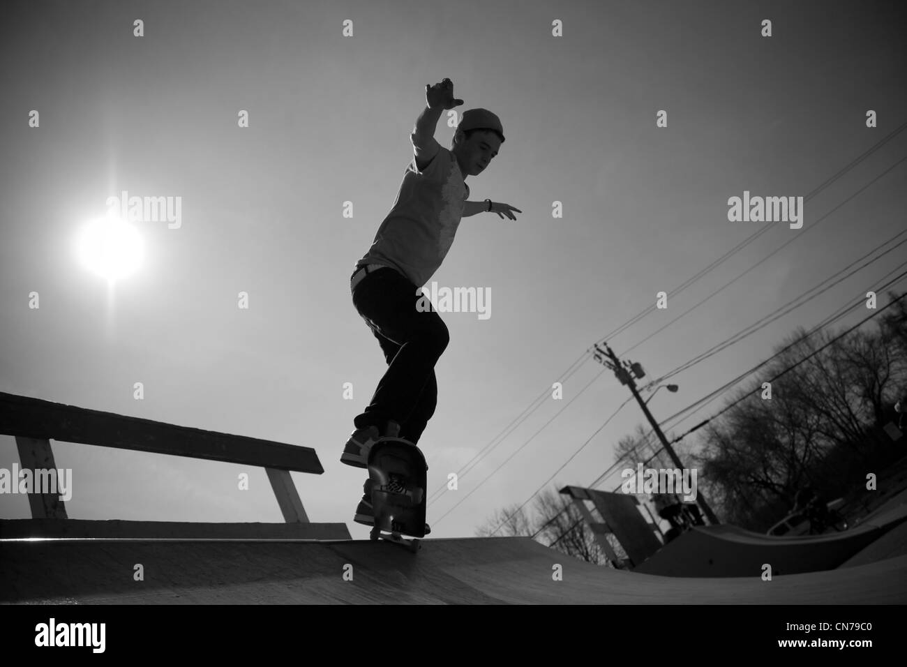 Portrait of a young skateboarder skating on a ramp at the skate park. Stock Photo