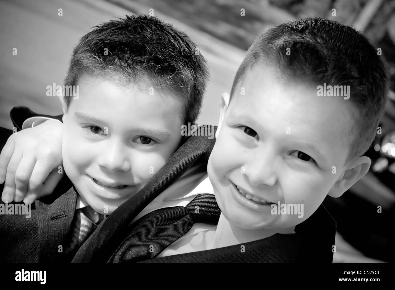 Two happy young boys dressed in suits with smiles on their faces. Black and white. Stock Photo
