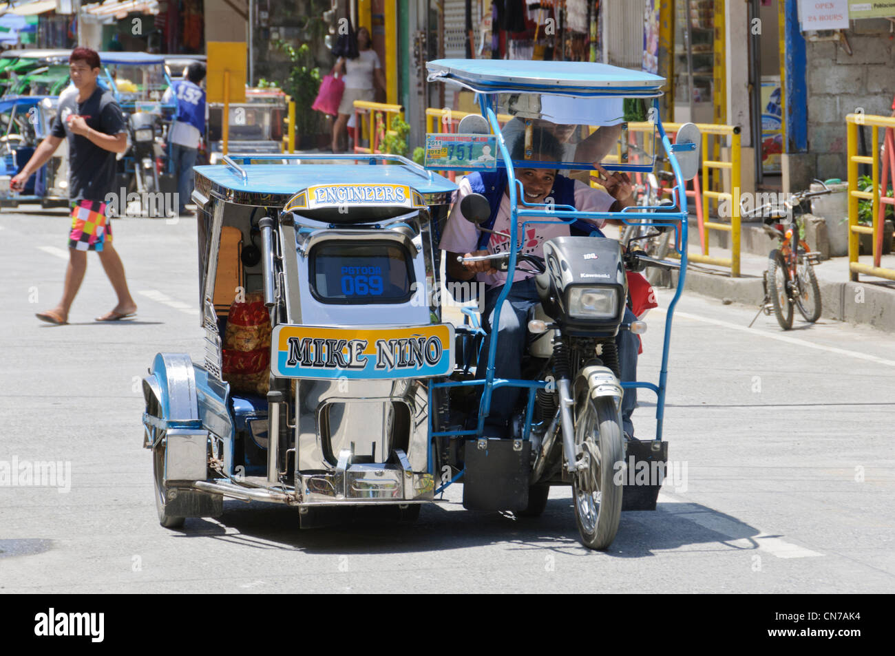 Tricycle side-car smiling male driver pedestrians Street Scene Puerto Galera, Oriental Mindoro, Philippines, Southeast Asia Stock Photo