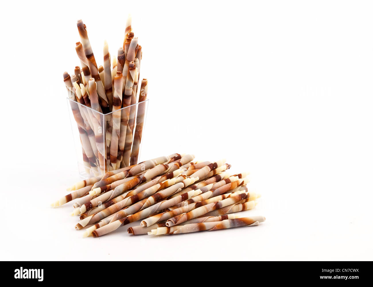 Chocolate decoration curled Sticks in a plastic glass isolated on white background Stock Photo