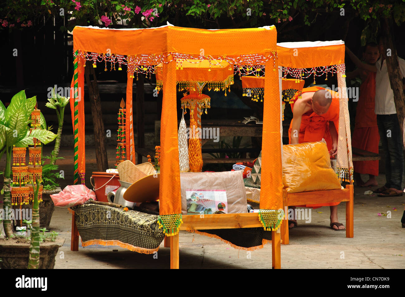 Monk arranging decorative Buddhist stands, Sakkaline Road, Luang