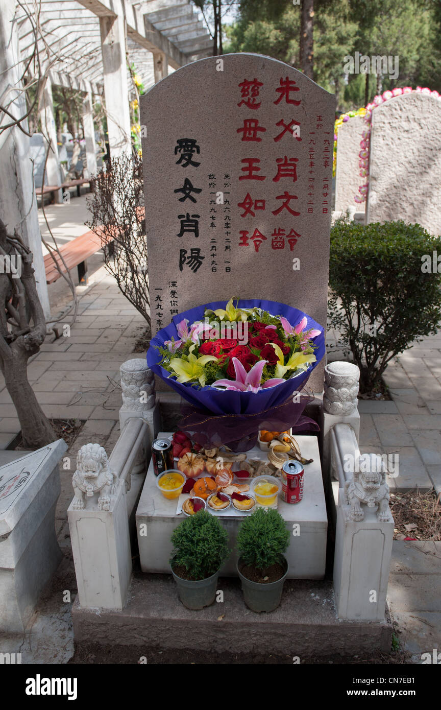 Beijing, Wanan cemetery. Grave with flowers and food offerings during