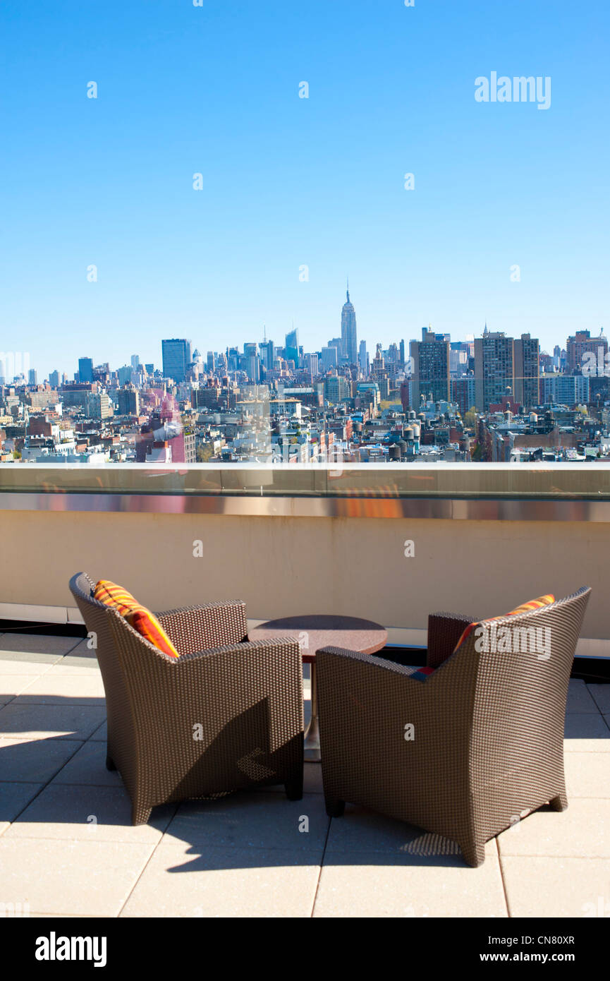 USA New York City NY NYC two chairs alone on rooftop terrace view of Manhattan skyline Empire State Building Stock Photo