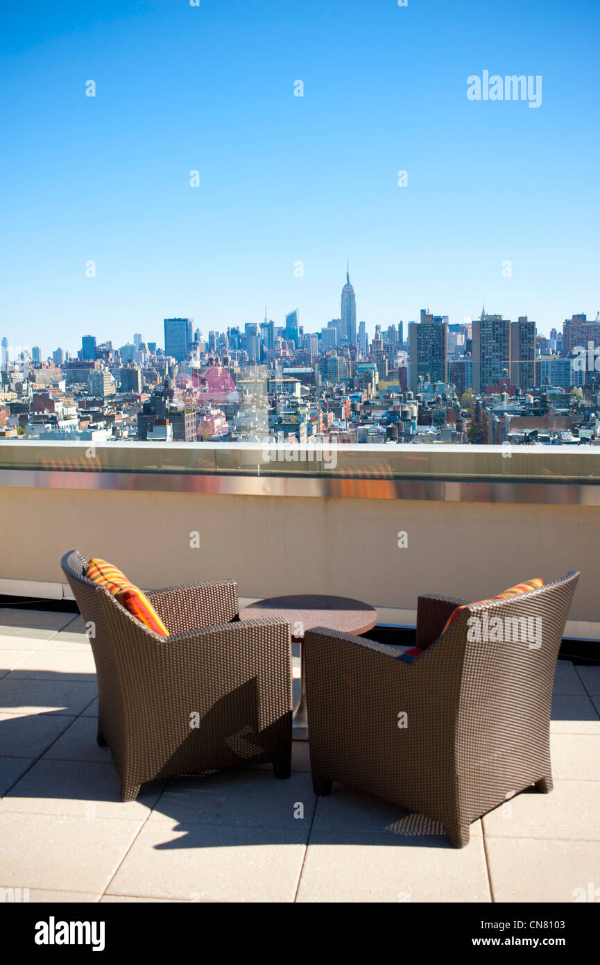 USA New York City NY NYC two chairs alone on rooftop terrace view of Manhattan skyline Empire State Building Stock Photo