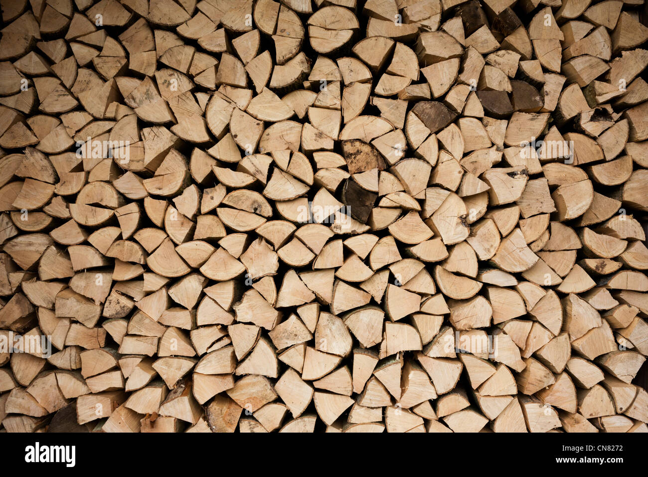 Piles of sawn logs, ready for a winter home fire, stays dry under cover on a small holding. Stock Photo