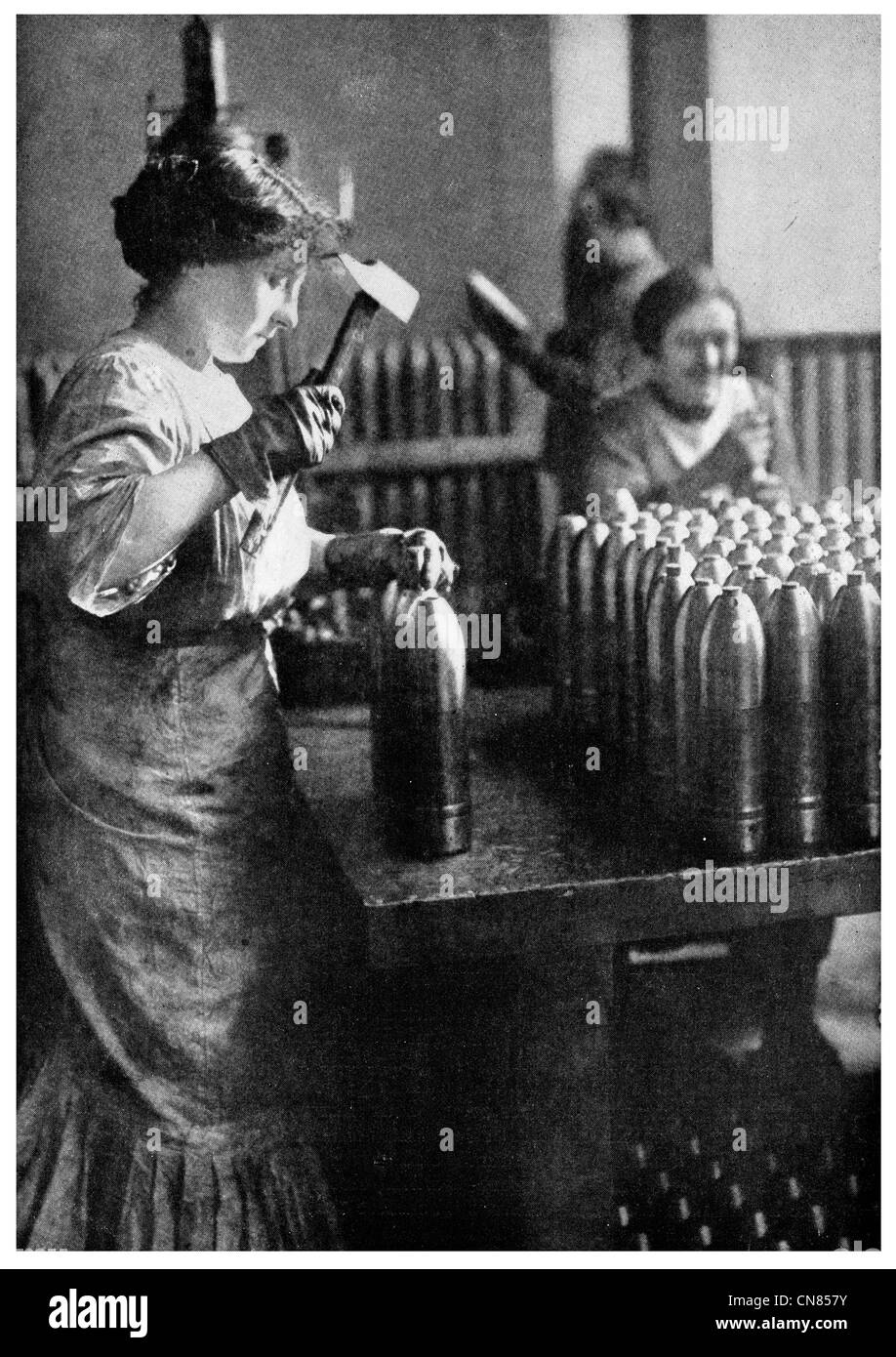 First published 1917 French Woman working ammunition Factory munition shell Stock Photo