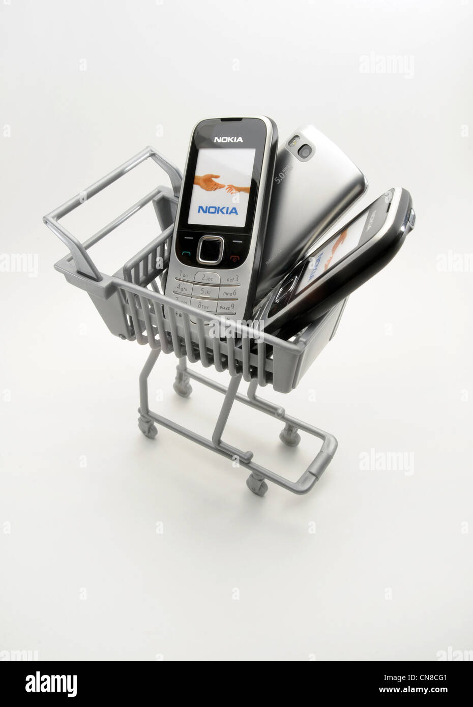 MOBILE PHONES IN SUPERMARKET SHOPPING TROLLEY RE SALES SELLING BUYERS BUYING CHOICE MAKERS PRICING PRICES PROVIDERS COSTS ETC UK Stock Photo