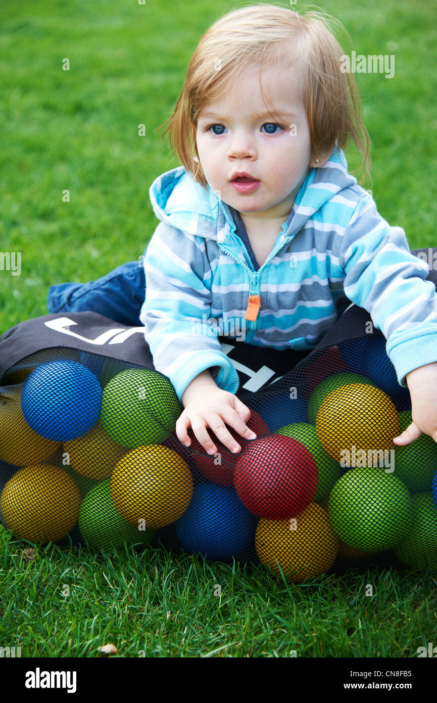 Child baby girl with bag of colorful balls Stock Photo Alamy