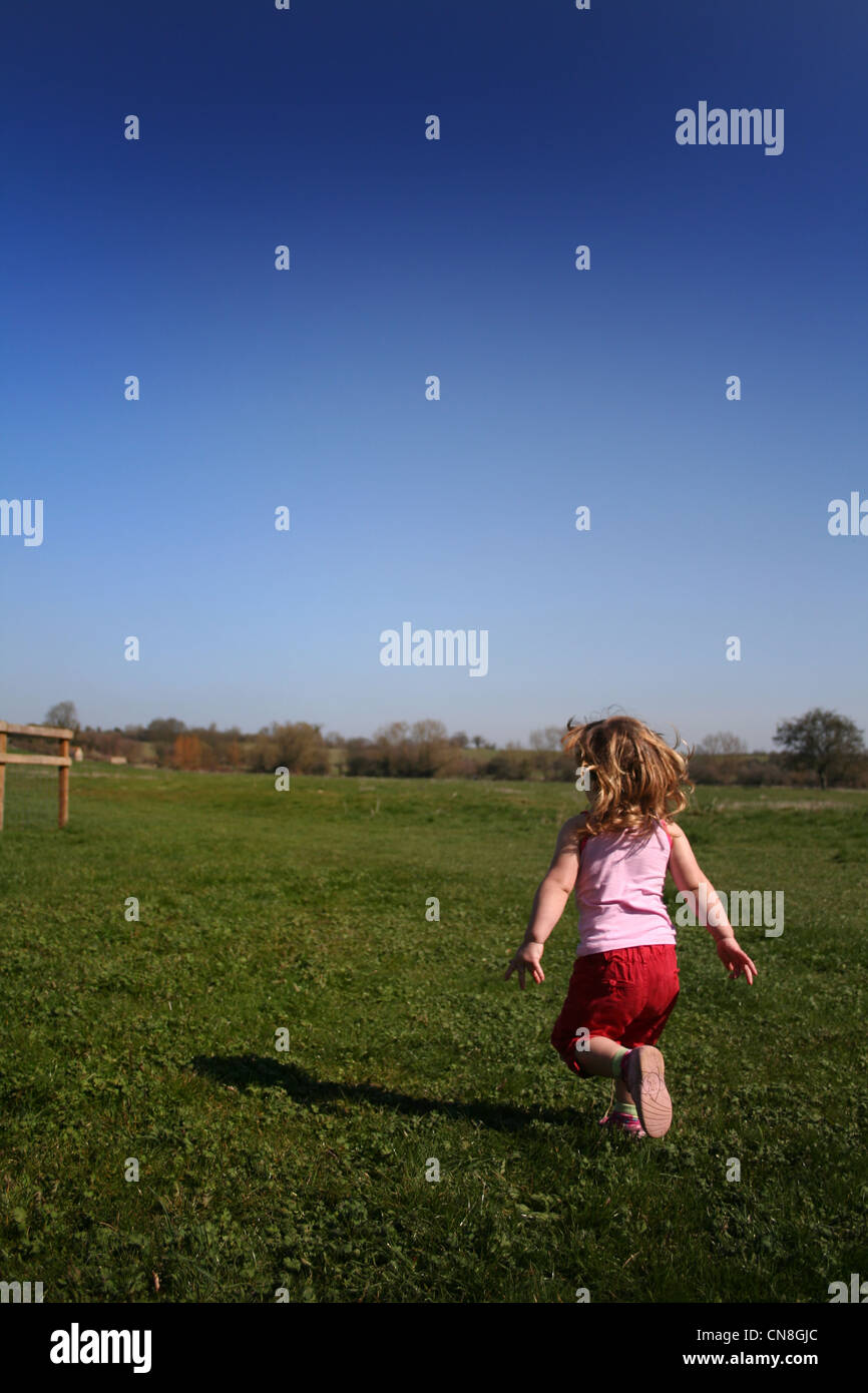 young girl running across field Stock Photo Alamy