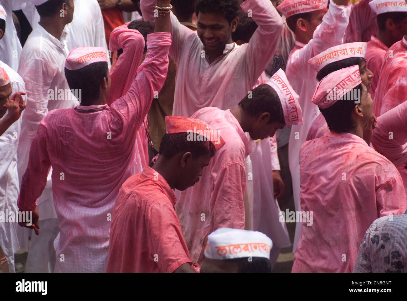 Devotees smeared in Pink Color during the Ganesh Visarjan procession - Lalbaug, Mumbai, India Stock Photo
