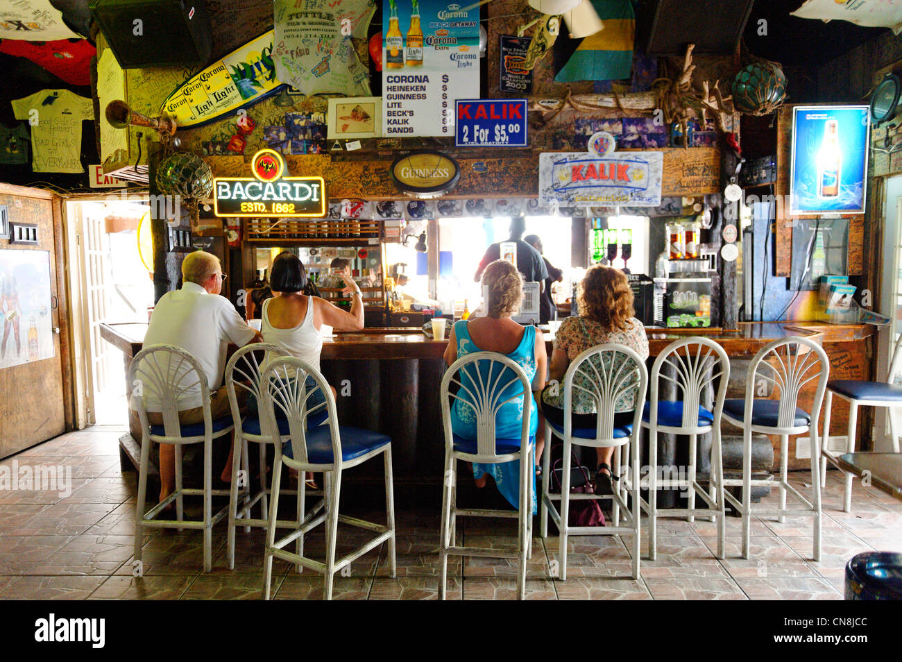 Bahamas, Grand Bahama Island, Freeport, Port Lucaya, Rum Runners Bar, customers sit at the counter of a rum bar Stock Photo