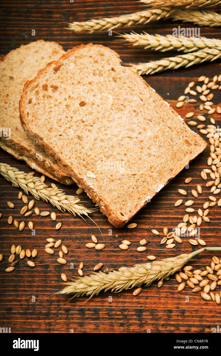 Wheat bread and grains and wheat ears on a wooden table Stock Photo - Alamy