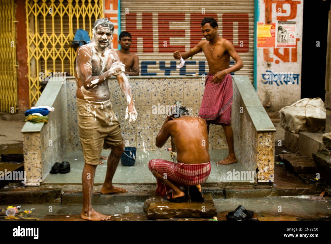 Men taking bath on the street of Kolkata  , India Stock Photo
