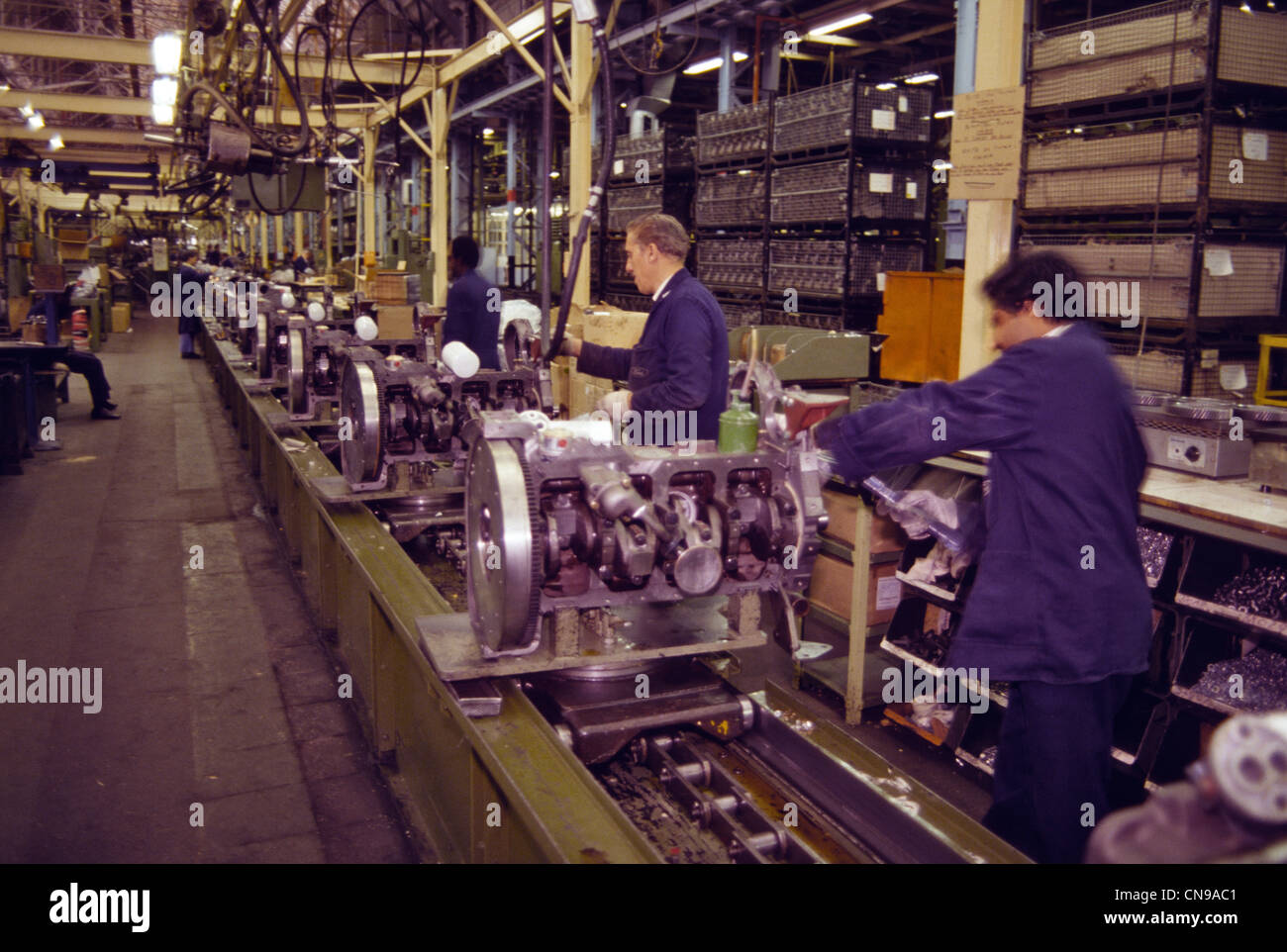 car manufacturers with assembly line of men working on engines Stock Photo