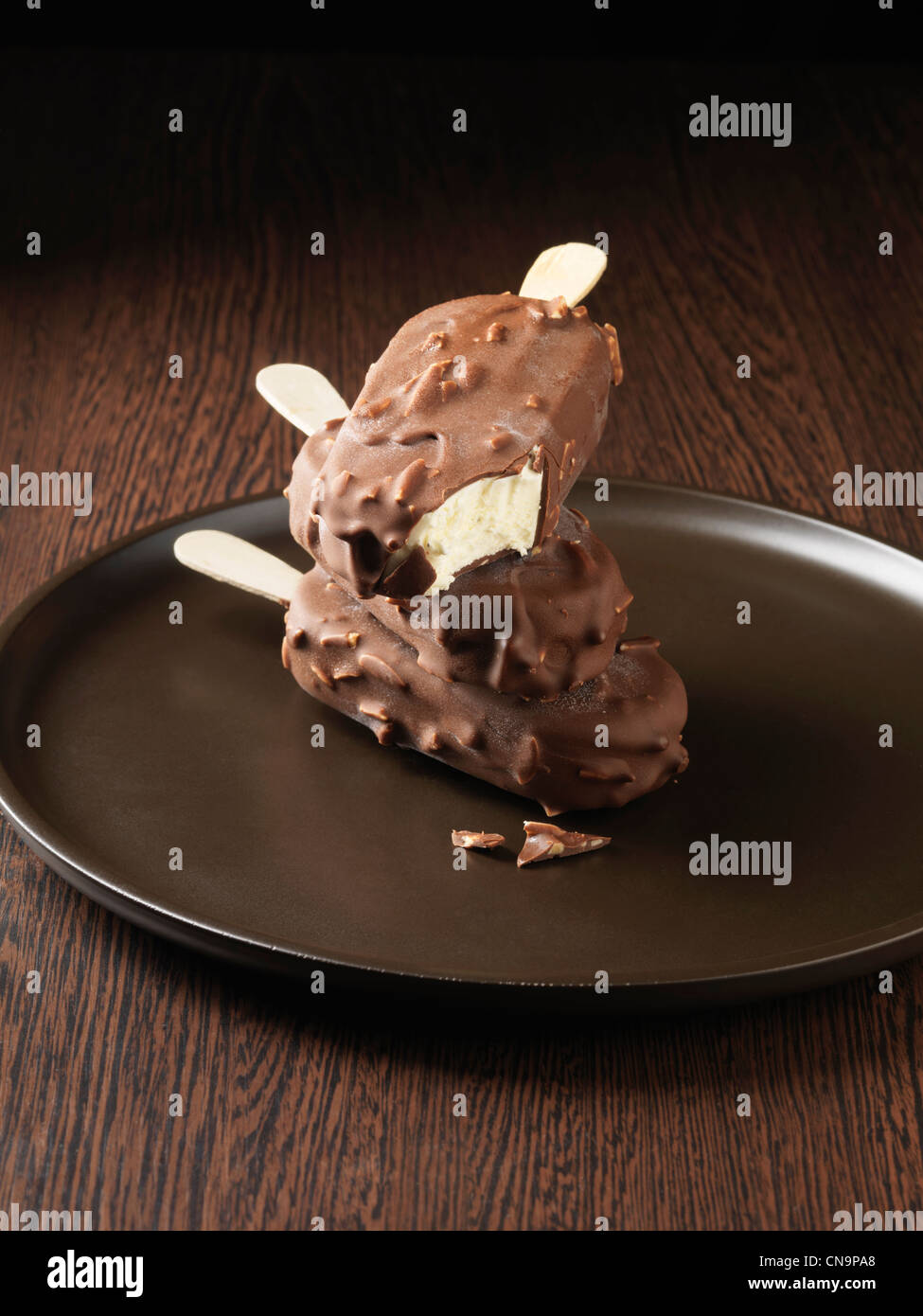 Dipped ice cream bars on wooden plate Stock Photo