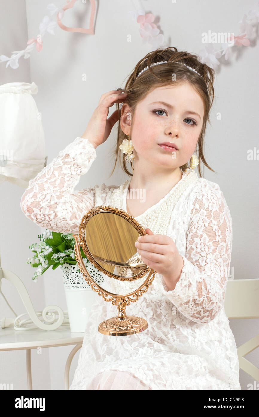 A beautiful little girl looking to small mirror Stock Photo - Alamy