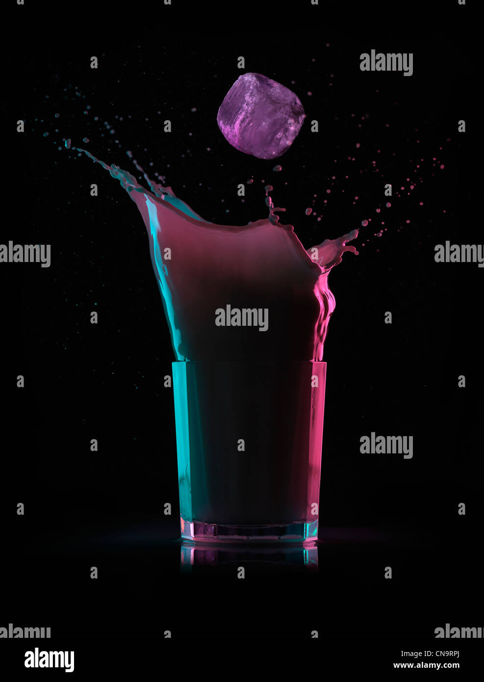 Ice cube splashing into drink Stock Photo - Alamy