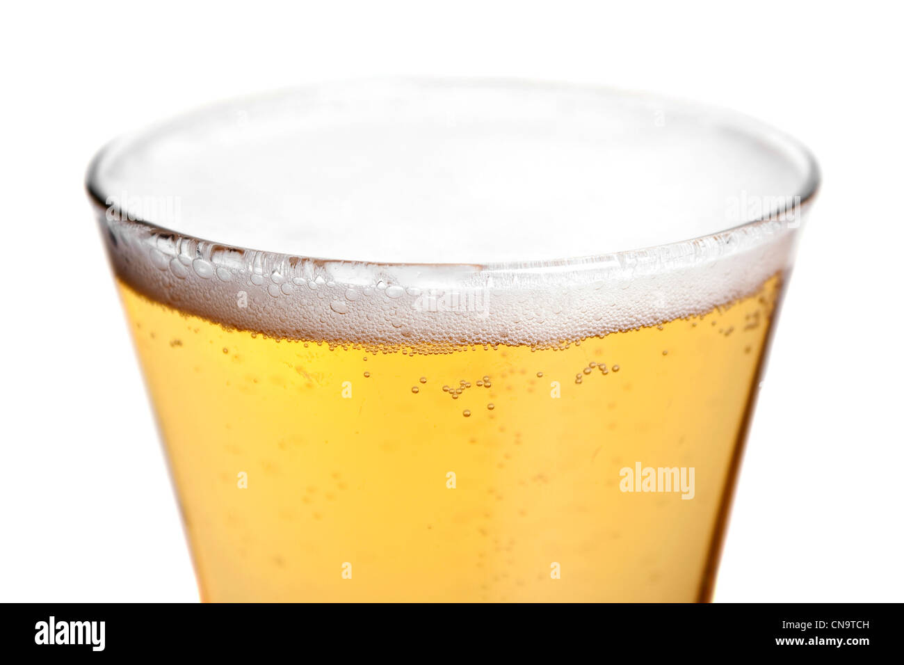 A pilsner glass with golden lager beer isolated over white. Shallow