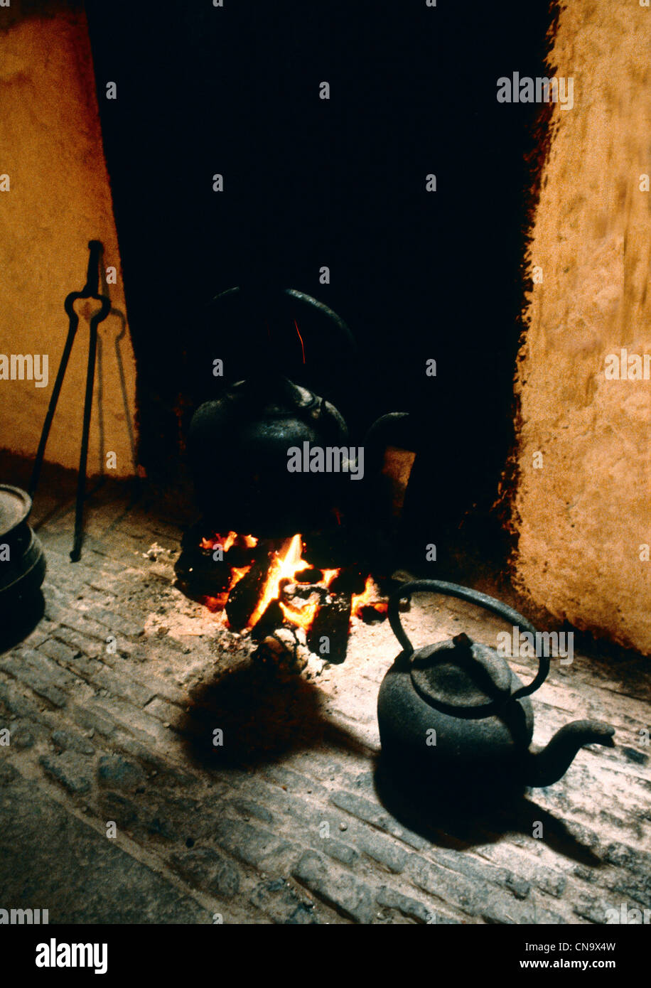 TURF BURNING IN A RURAL IRISH KITCHEN- THONGS ON THE LEFT CAST IRON KETTLE ON THE RIGHT Stock Photo