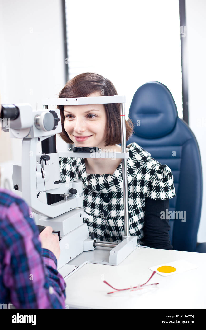 optometry concept pretty young woman having her eyes examined by an