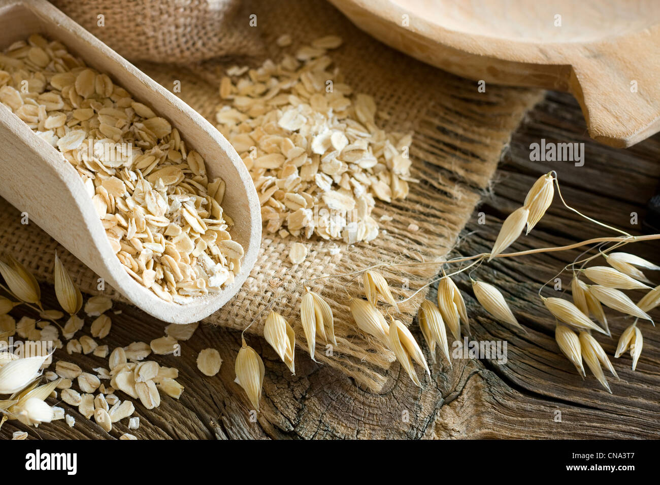 Oatmeal in old wooden spoon Stock Photo