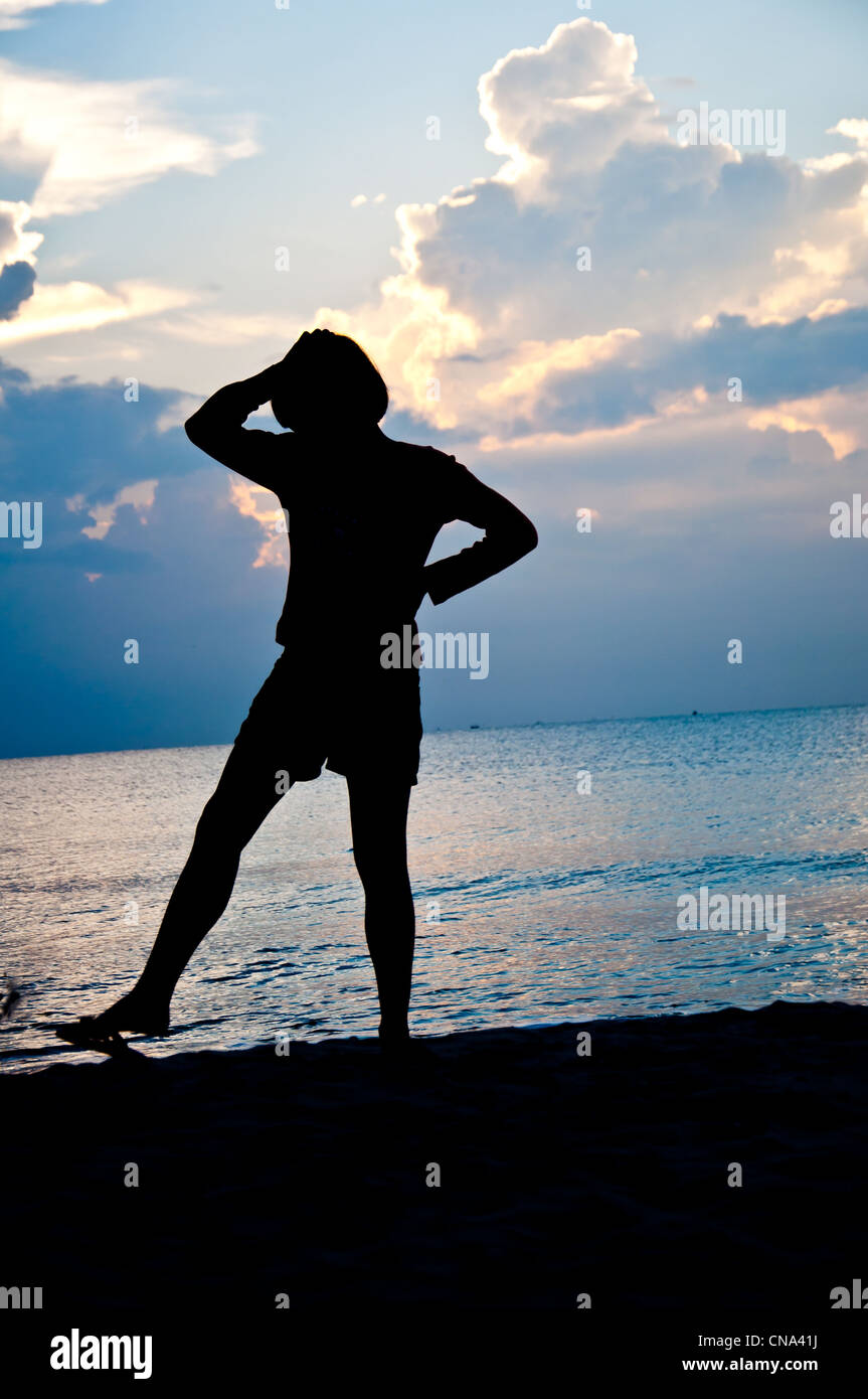 silhouette of girl feel free on the beach Stock Photo