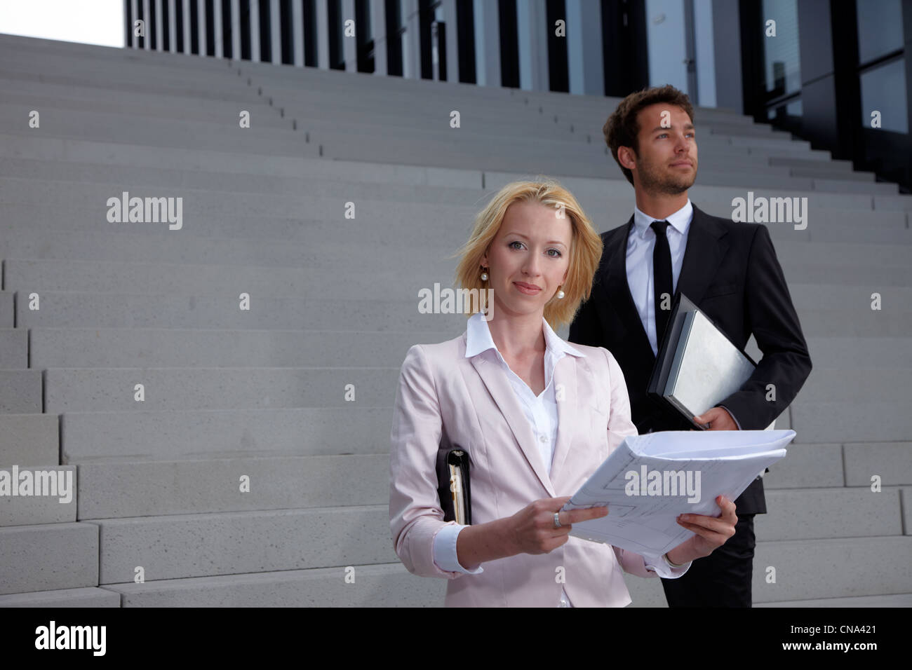 man and woman with plan standing on stairs Stock Photo