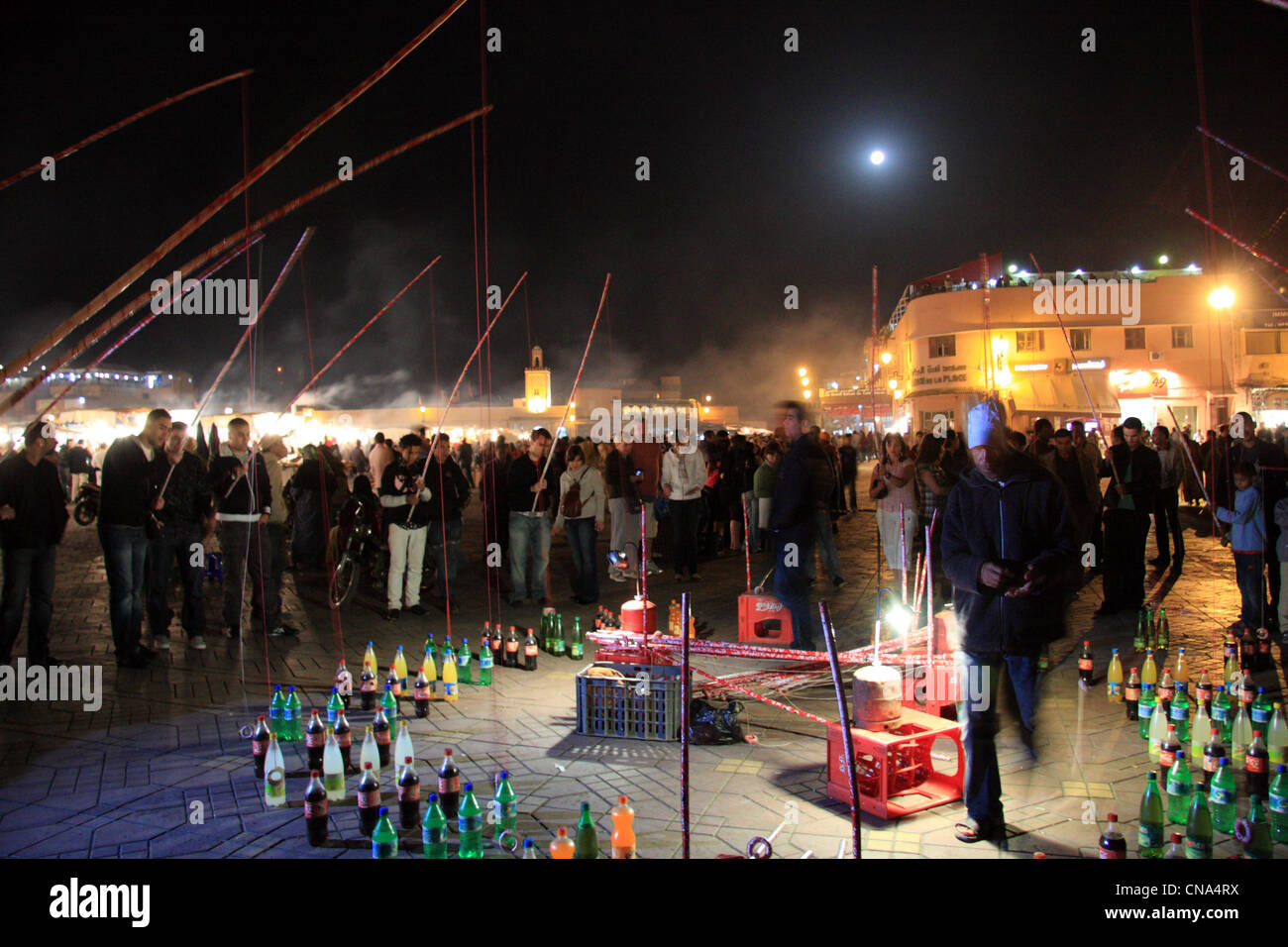 Moroccans playing hoopla with fishing rods over plastic bottles at night in Place Djemaa el-fna, Marrakech, Morocco, north Africa Stock Photo