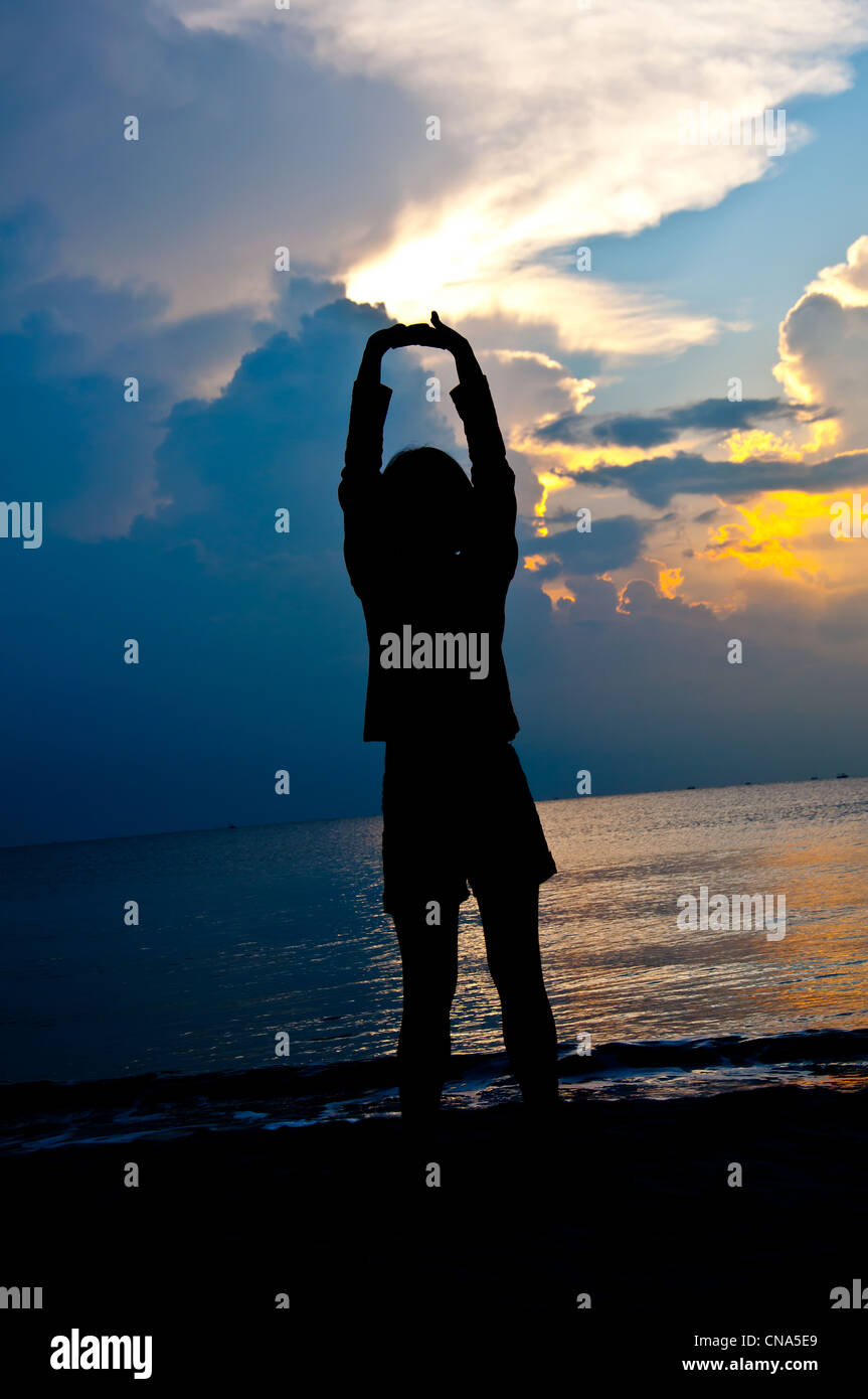 silhouette of girl relaxation on the beach in the morning Stock Photo ...