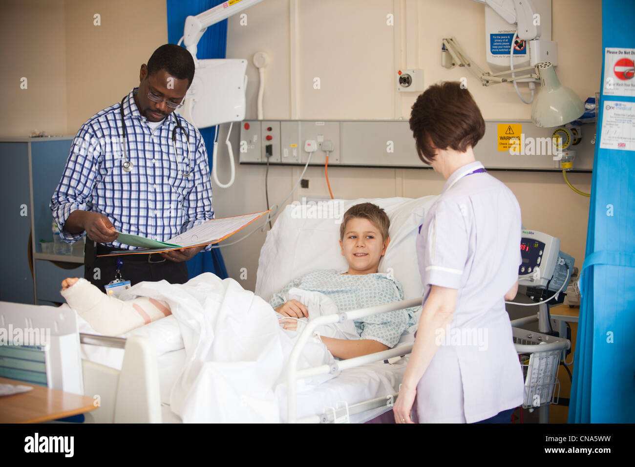 A young boy is checked by a doctor and nurse on a children's hospital