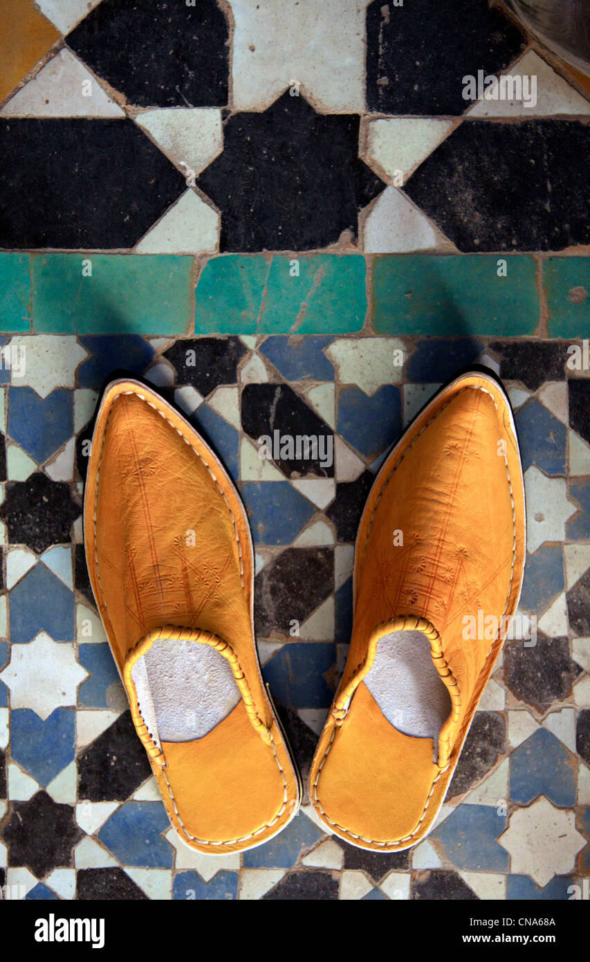 A pair of traditional Moroccan slippers-shoes, or babouche against traditional mosaic tile work (zellij) in Marrakech, Morocco Stock Photo