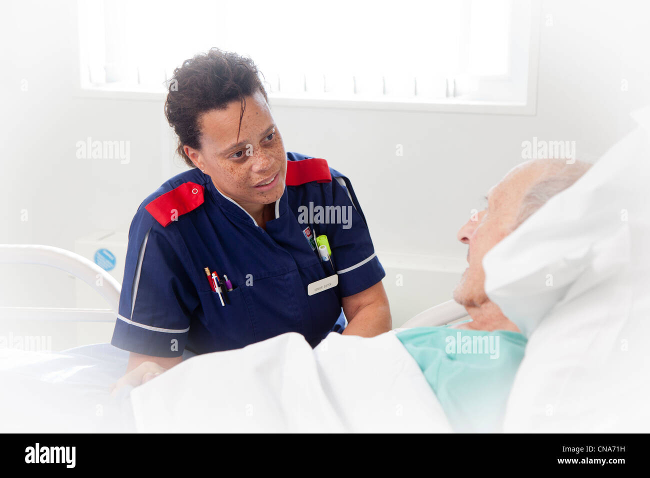 An elderly male patient being comforted by a nurse UK Stock Photo