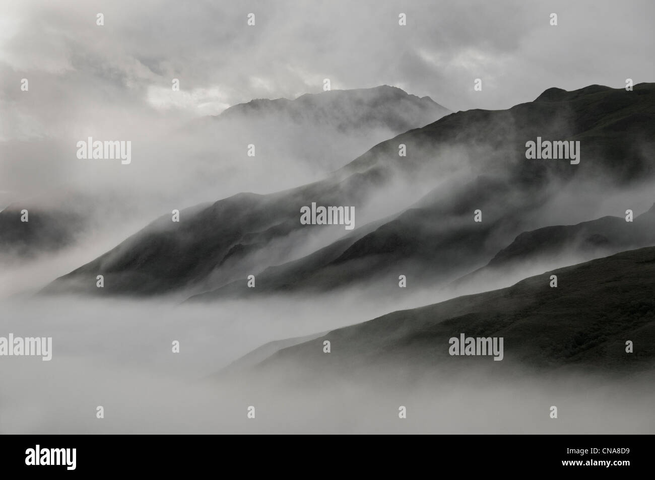 Early morning mist swirls through the Alaska Range of mountains in Denali National Park, Alaska. Stock Photo