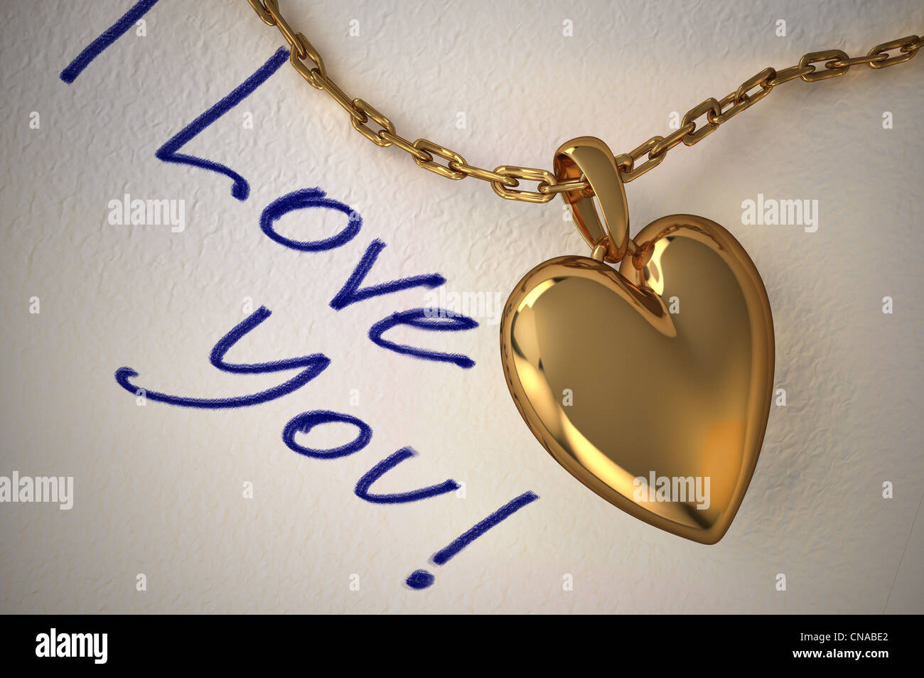 Gold heart pendant on a white paper with the type I love you, hand written on it. Stock Photo