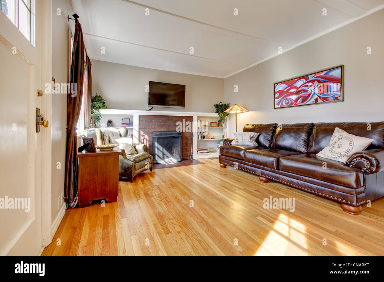 Living Room With Leather Sofa Fireplace And Tv And Red Painting