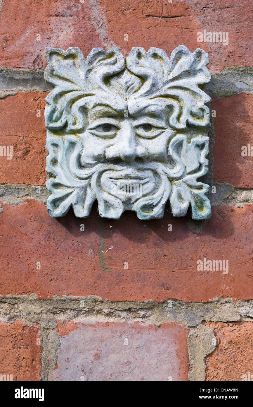 Green Man plaque on an old redbrick wall. Stock Photo