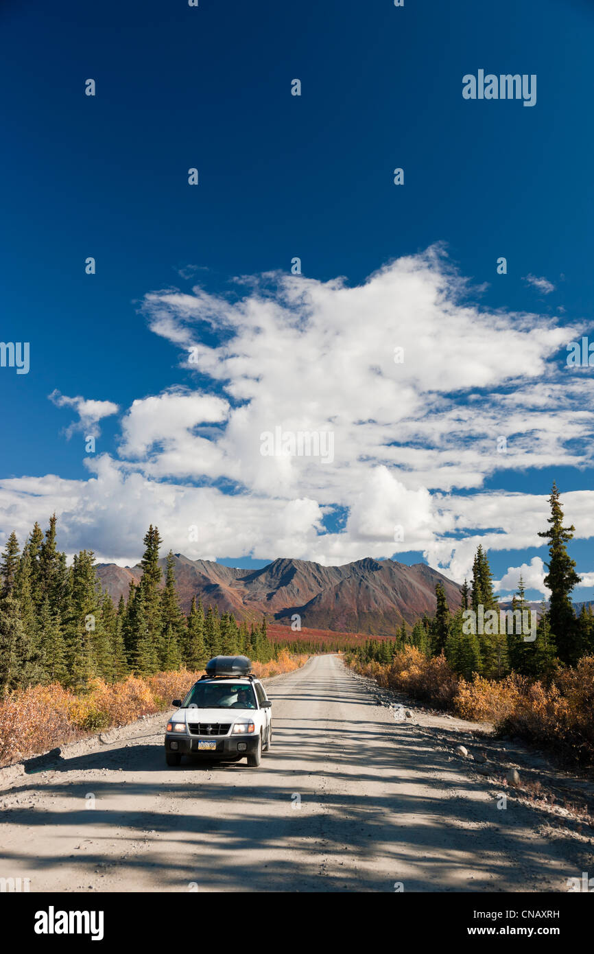 Car driving on the Denali Highway amongst Fall foliage and scenery