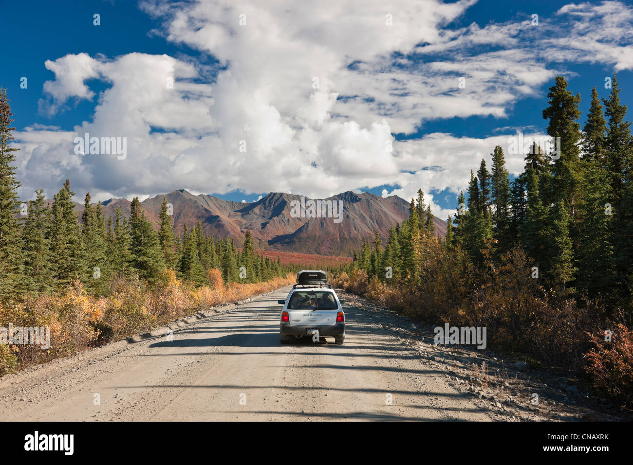 Car driving on the Denali Highway amongst Fall foliage and scenery