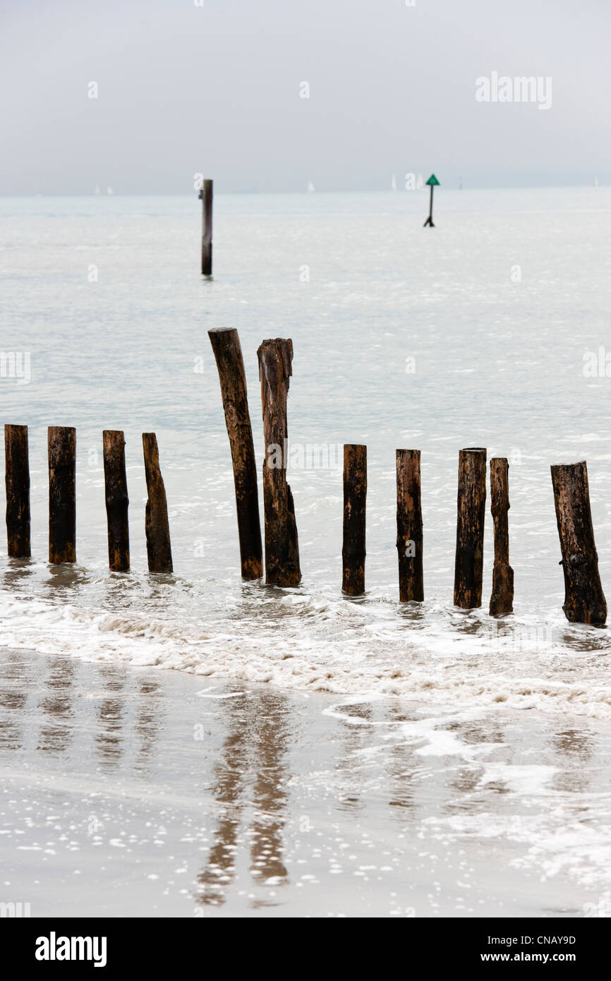 Groynes which are used as a sea defence to reduce erosion seen here at the beach West Wittering ,West Sussex at Spring tide Stock Photo