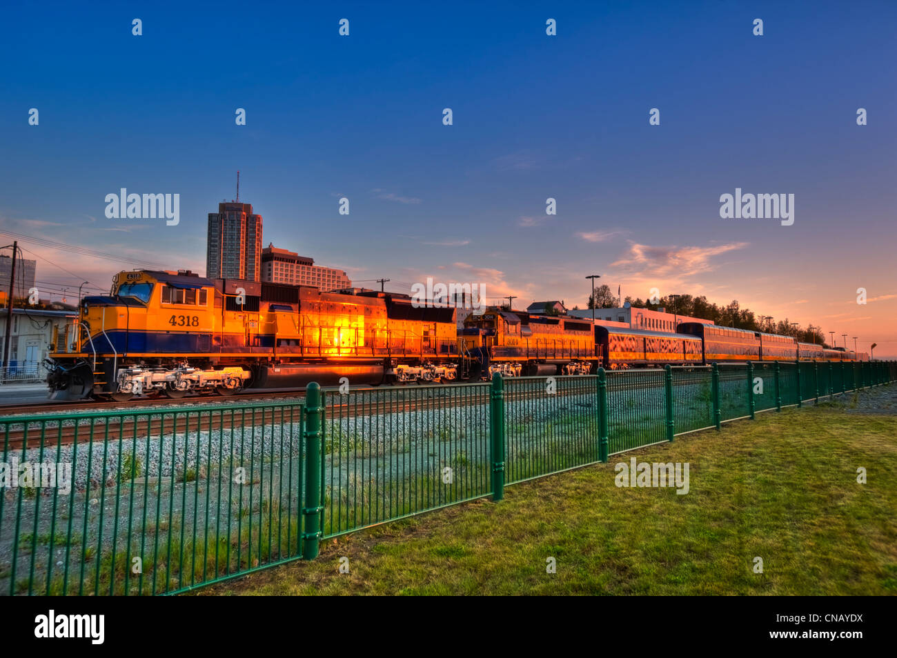 Alaska Railroad train passes through downtown Anchorage in the evening, Southcentral Alaska, Summer. HDR Stock Photo