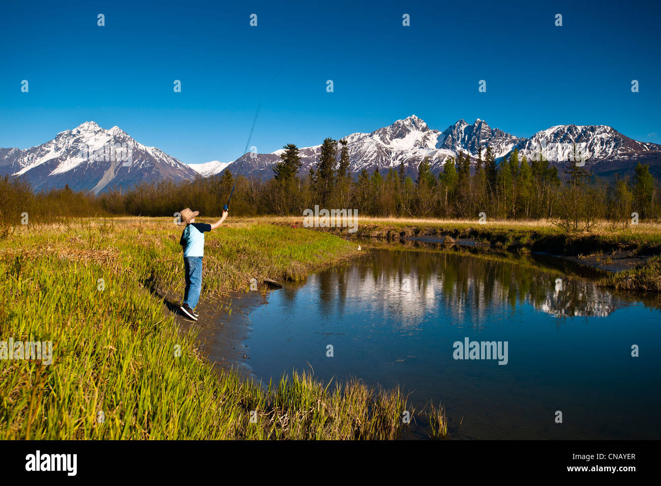 A young boy fishing on Rabbit Slough on a sunny spring day in the