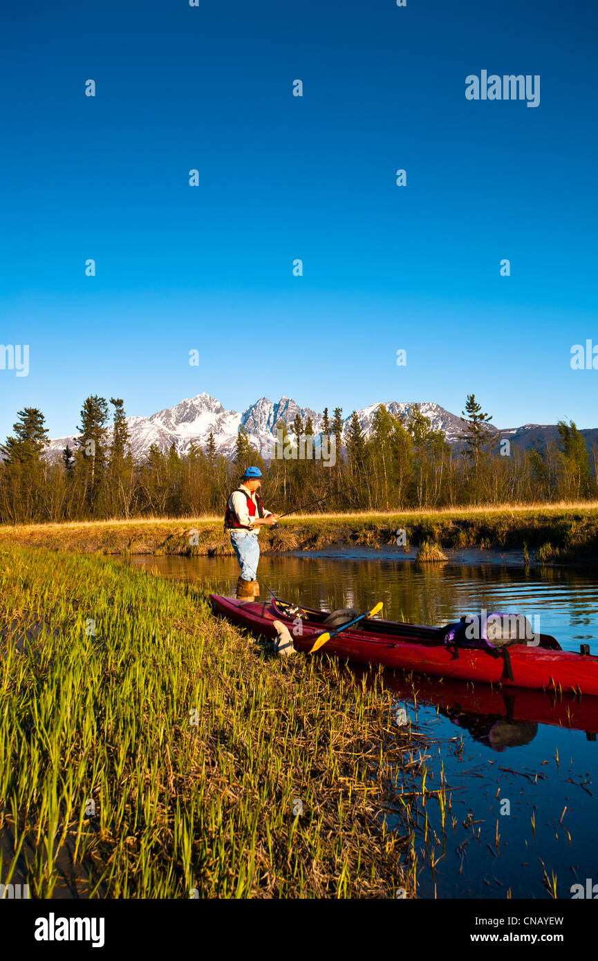 Man with a kayak fishing from the shore of Rabbit Slough in the Palmer