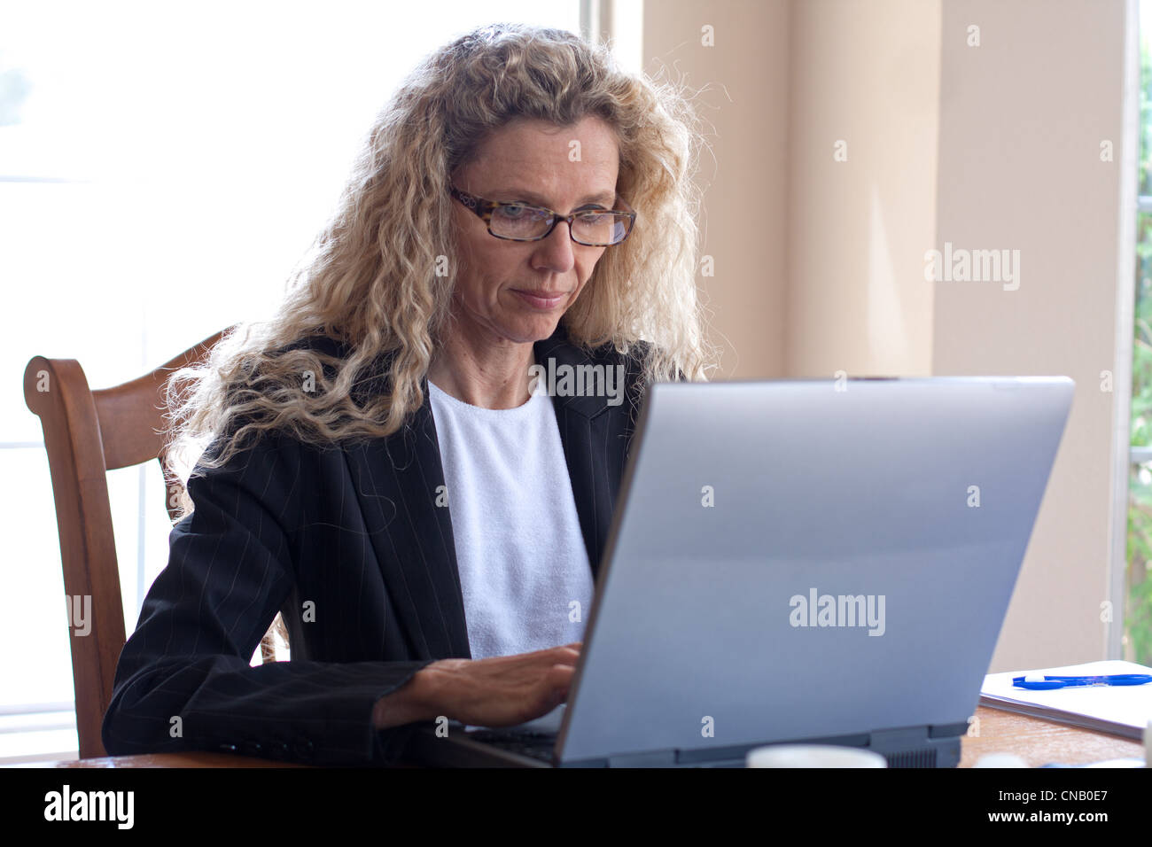Mature woman on laptop working and typing Stock Photo - Alamy