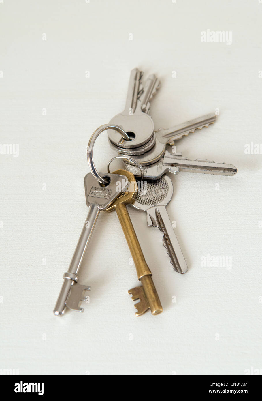 Bunch of various house keys taken against a light coloured wooden table Stock Photo