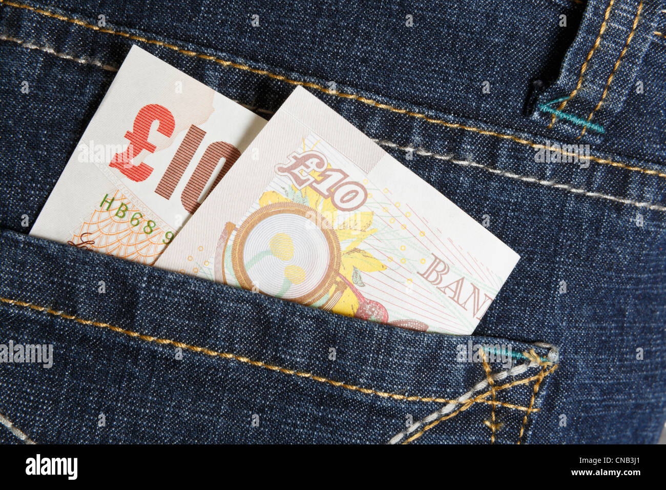 A ten pound note in the back pocket of a pair of women's blue denim