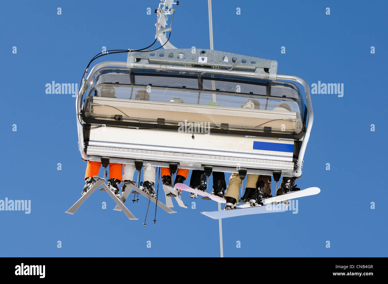 a ski lift with skiers before blue sky Stock Photo - Alamy