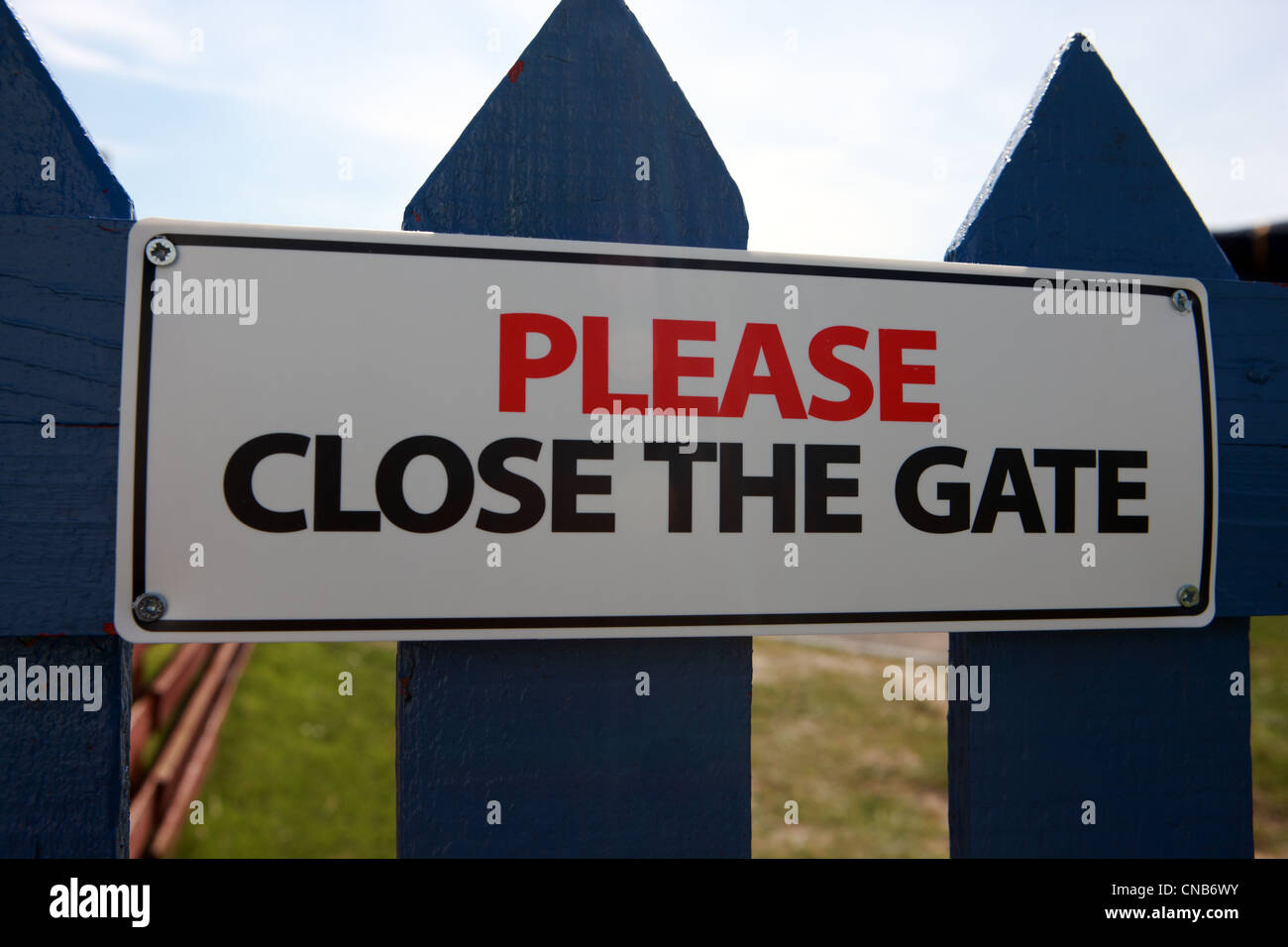 Please close the gate sign on a blue gate Stock Photo Alamy