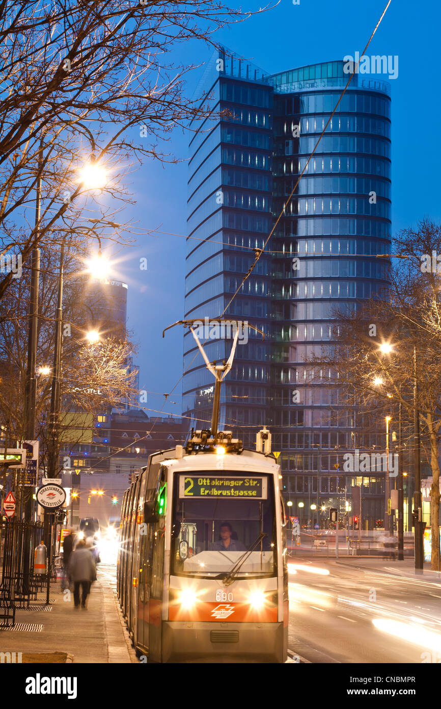Austria, Vienna, tramway with UNIQA Tower in the background, designed by Austrian larchitect Heinz Neumann, located along the Stock Photo