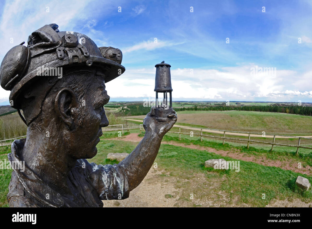 Bronze memorial statue of a coal miner holding up a Davy safety lamp in honor to all the coal mines in Nottinghamshire. Stock Photo