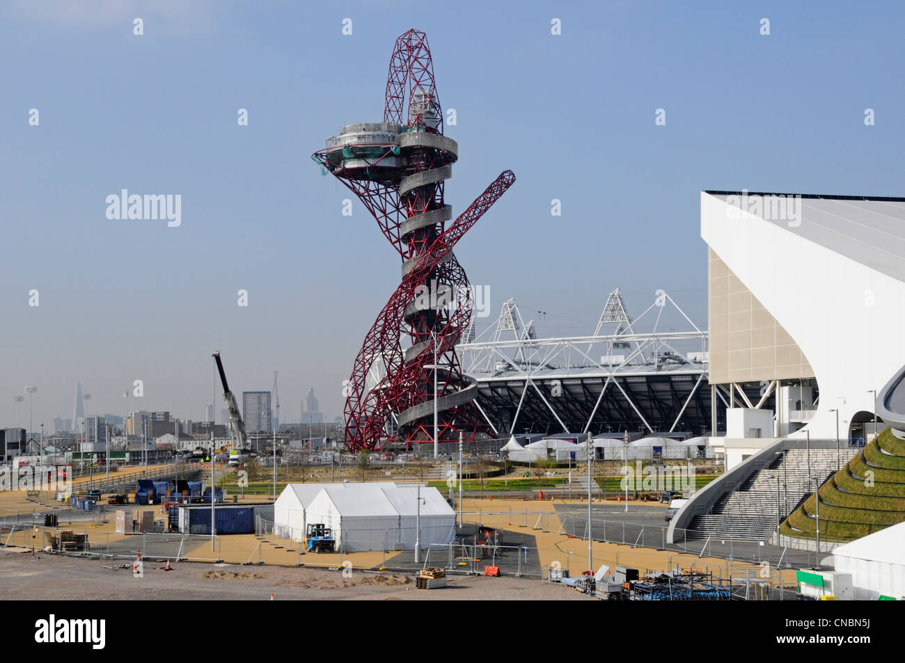 Arcelor Mittal Orbit tower in 2012 London Olympic park main stadium middle &aquatics pool wing stand right Stratford Newham East London England Stock Photo
